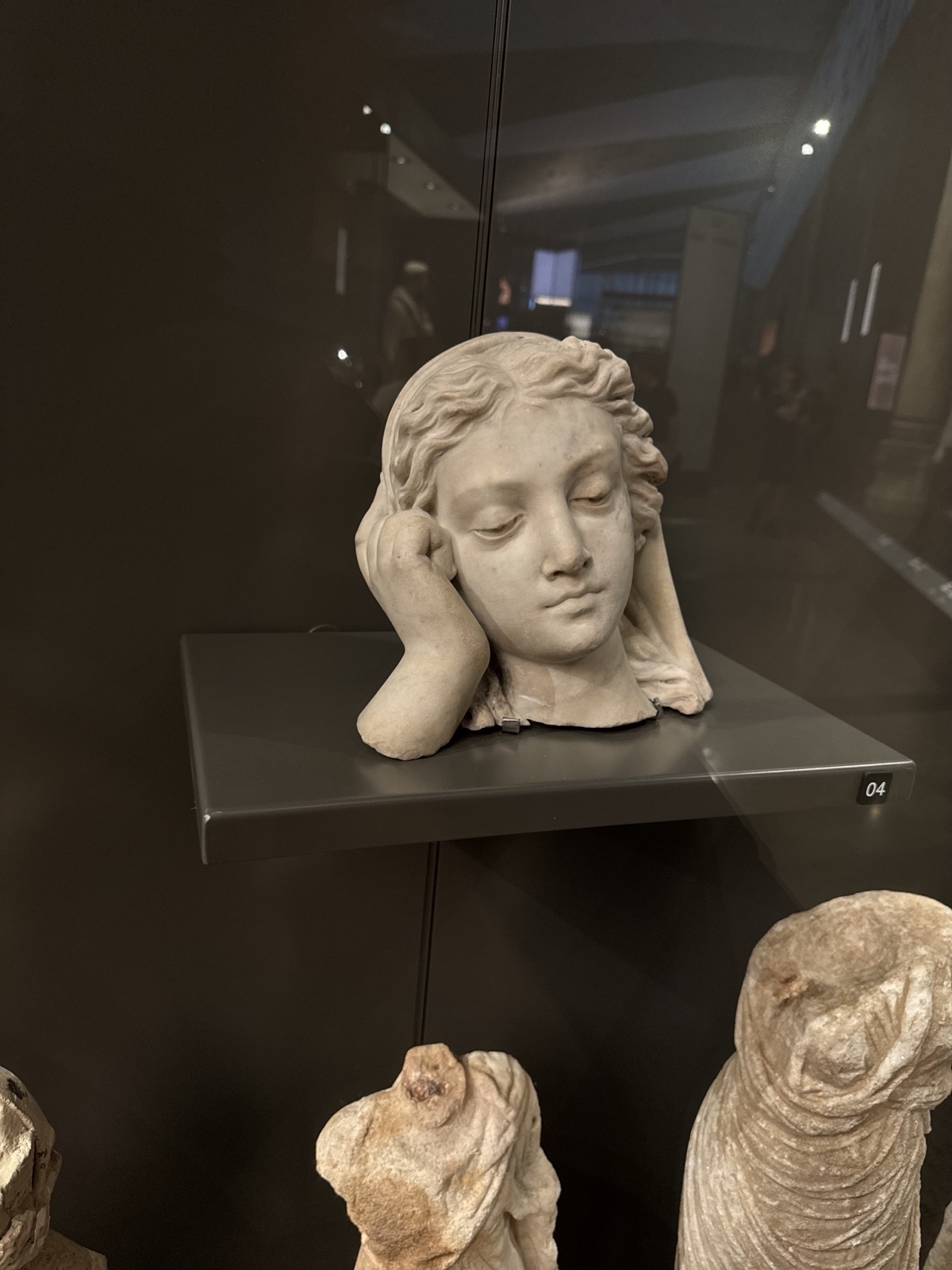 "Weeping Lady" — a marble head, weary or mourning in expression, resting on one hand